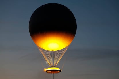 El pebetero se eleva en el aire enganchado a un globo aerostático sobrevuela Paris.