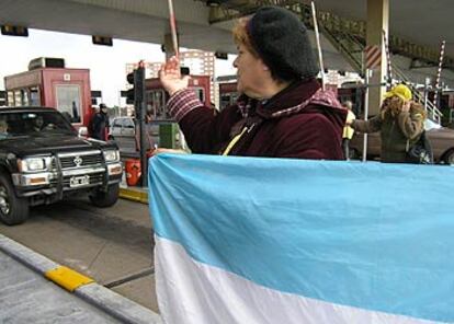 Una mujer <i>piquetera</i> pide a los automovilistas que pasen el puesto de peaje en el aeropuerto de Ezeiza.