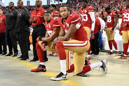 Colin Kaepernick (en primer plano) y su compañero Eric Reid, con la rodilla derecha en el suelo durante el himno nacional en un partido del 11 de septiembre de 2016 en Santa Clara (California).