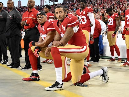 Colin Kaepernick (en primer plano) y su compañero Eric Reid, con la rodilla derecha en el suelo durante el himno nacional en un partido del 11 de septiembre de 2016 en Santa Clara (California).