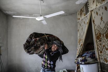 Un hombre kurdo traslada sus pertenencias a su casa en la ciudad Siria de Kobane.