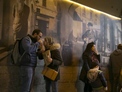 Personas comiendo churros a las puertas de la chocolatería San Ginés.