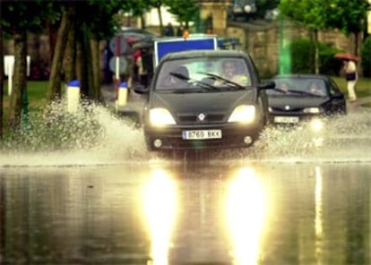 Un coche atraviesa una balsa de agua formada en el acceso al Palacio de La Magadalena en Santander, tras caer en la ciudad la mayor tormenta de los últimos 22 años, con 27 litros por metro cuadrado en 10 minutos.