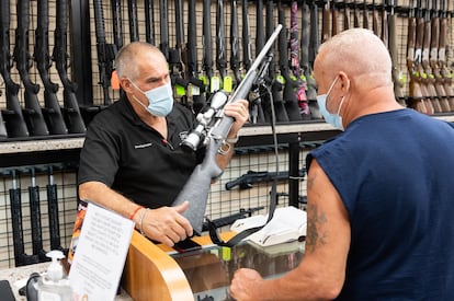 Un vendedor de armas muestra un rifle a un cliente en una tienda de Nueva York