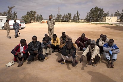 Un grupo de inmigrantes indocumentados es custodiado junto al centro de internamiento para extranjeros en Misrata, Libia.