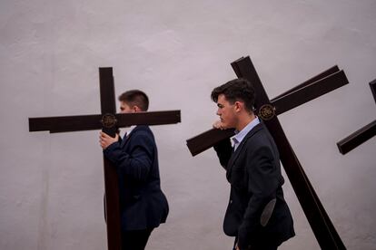Dos jóvenes sujetan varias cruces en la plaza de los Capuchinos en Córdoba, el 22 de marzo.