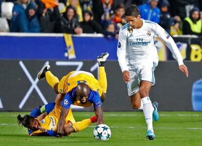 Raphael Varane se lleva el balón ante los jugadores del Apoel Efstathios Aloneftis y Mickael Pote.