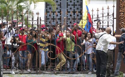 Venezuelanos que apoiam o Governo forçam a entrada no Parlamento, em Caracas.