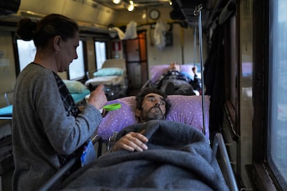 Yuri Chucha, un paciente oncológico de 52 años originario de la asediada Bajmut, junto a su mujer Ana, de 48, en el tren hospital en el que están siendo evacuados de la región de Donetsk (Ucania), el 28 de febrero. 