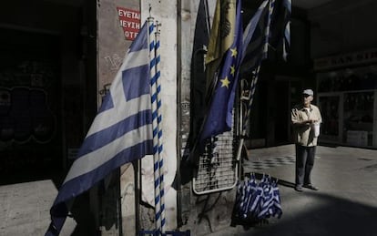 Um idoso em frente a uma loja que vende bandeiras gregas e da UE no centro de Atenas.