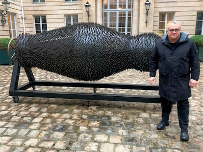 Ukraine's Mikhail Reva poses next to one of his art pieces, Thursday, Feb. 22, 2024 in Paris.
