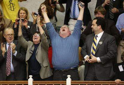 Kirk Bloodsworth, vestido de azul, el primer condenado a muerte que fue exonerado con una prueba de ADN, celebran el voto de la Cámara de Representantes de Maryland para acabar con la máxima pena.