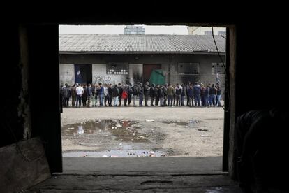 Un grupo de migrantes hace cola para recibir comida gratis a las afueras de un almacén abandonado en Belgrado (Serbia).