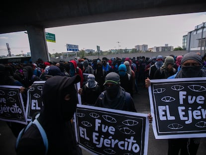 Manifestantes por Ayotzinapa llevan carteles que culpan al ejército de las desapariciones.