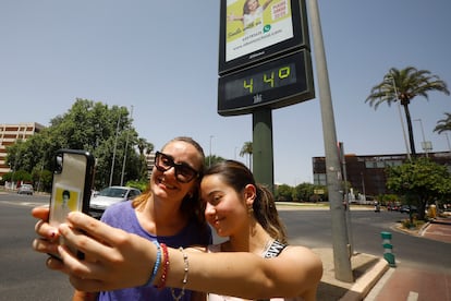 Dos turistas se fotografiaban el domingo junto a un termómetro que marcaba 44 grados en Córdoba. 
