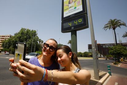 Dos turistas se fotografiaban el domingo junto a un termómetro que marcaba 44 grados en Córdoba. 
