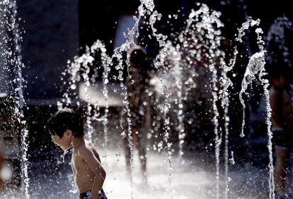 Un niño se refresca en una fuente de Tokio para paliar las altas temperaturas que se están viviendo en la ciudad japonesa.