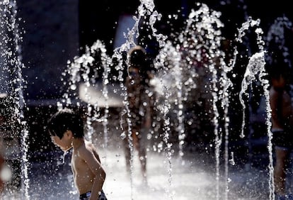 Un niño se refresca en una fuente de Tokio para paliar las altas temperaturas que se están viviendo en la ciudad japonesa.