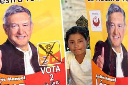 Una niña asoma entre dos carteles electorales del candidato Andrés Manuel López Obrador, ayer en Puebla.