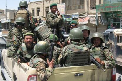 Más de una decena de miembros del Ejército de Afganistan viajan armados en un camión militar.