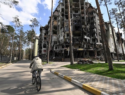 Un hombre en bici pasa junto a un edificio residencial destruido en Irpin, al noroeste de Kiev, el pasado 24 de abril.