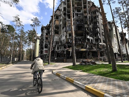 Un hombre en bici pasa junto a un edificio residencial destruido en Irpin, al noroeste de Kiev, el pasado 24 de abril.