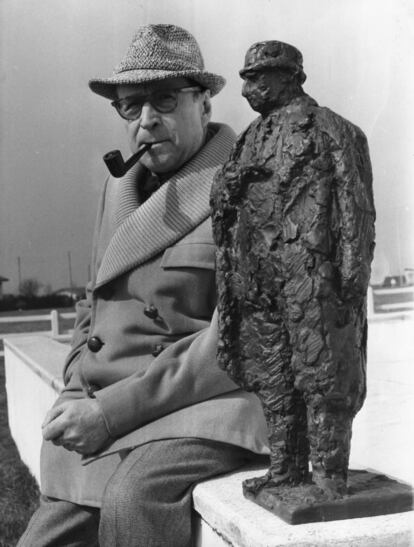 El novelista belga Georges Joseph Christian Simenon (1903 - 1989), junto a una escultura de su detective Maigret.