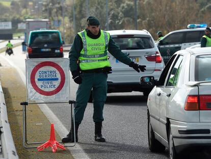 Un guardia civil para un coche en la frontera entre Tui y Valenca, este lunes.