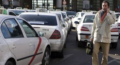 Un hombre habla por el móvil junto a la parada de taxis de Atocha, en Madrid.