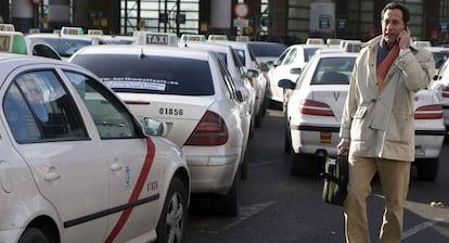 Un hombre habla por el móvil junto a la parada de taxis de Atocha, en Madrid.