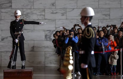 Un grupo de turistas toma fotos durante el cambio de guardia en el salón conmemorativo de Chiang Kai-shek en Taipei, Taiwán.