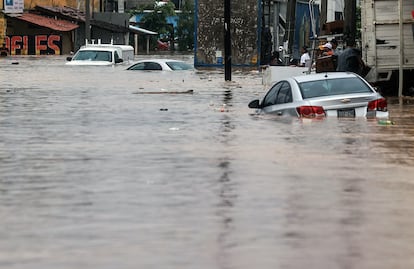 Autos afectados en una calle inundada en Acapulco.