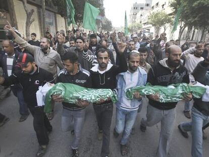 Hombres palestinos sostienen los cadáveres de dos niños, durante su funeral en Gaza.