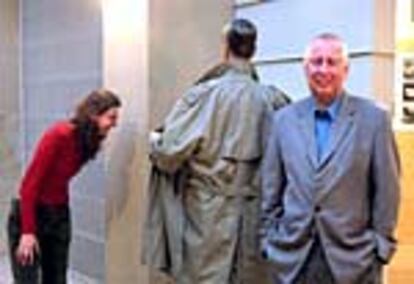 Hans-Peter Feldmann, a la derecha, sonríe mientras una visitante observa una de las obras de su exposición.