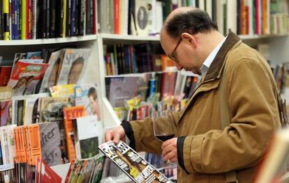 Un cliente de la librería Cámara mira, ayer, una revista mientras degusta una copa de vino.