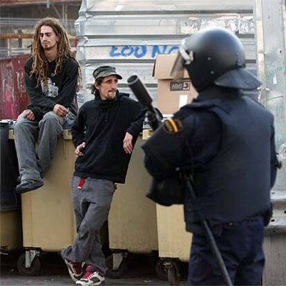 Dos <i>okupas</i>, frente a un policía antidisturbios que participó en el desalojo de ayer.