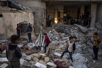 Palestinians look at the destruction after an Israeli strike in Rafah, southern Gaza Strip, Friday, Dec. 29, 2023.