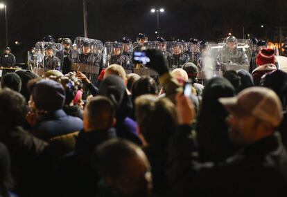 La tensión racial se preveía desde horas antes de conocerse la decisión del gran jurado sobre Michael Brown. En la foto, la policía acordona el departamento de policía de Ferguson mientras los manifestantes esperan el resultado de la deliberación.