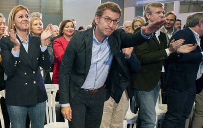 Feijóo y la secretaria general del PP, María Dolores de Cospedal, saludan durante el XVI Congreso Autonómico celebrado en Ourense.