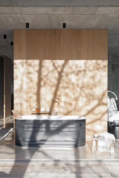 La bañera abierta al
exterior adquiere un gran
protagonismo en la suite.
Diseñada por Patricia
Urquiola para Agape,
su acabado en acero gris
resalta sobre el panelado
de madera. La grifería
es de la firma KWC.