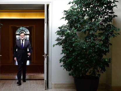 Mariano Rajoy cruza una puerta en La Moncloa.