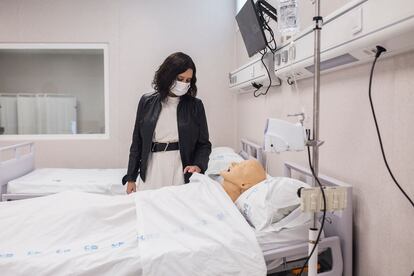 La presidenta de la Comunidad de Madrid, Isabel Díaz Ayuso, observa un maniquí que simula a un paciente durante su visita al Complejo Hospitalario 12 de Octubre, a 6 de abril de 2021, en Madrid (España).