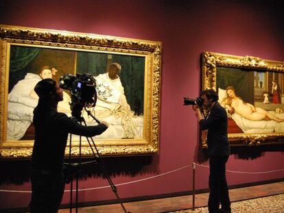 Un c&aacute;mara y un fot&oacute;grafo franc&eacute;s delante de &#039;Olympia&#039; de Manet y, a la derecha, &#039;La Venus de Urbino&#039; de Tiziano.