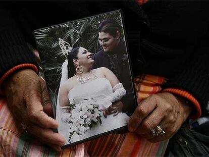 Las manos de 65 años de Lola Fernández sostienen la foto de boda gitana de unos vecinos, antes casados por lo civil. Una generación abre paso a la que establecerá otro modo de ser gitano.