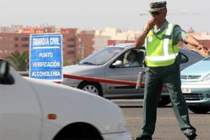 Un guardia civil da el alto a un vehículo para un control de alcoholemia en el peaje de la Autopista AP-7, a la altura de Campello (Alicante).