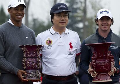 Tiger y McIlroy sostiene los galardones.