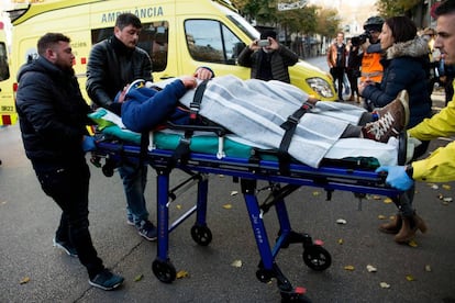 A wounded man receives medical assistance following clashes between riot police and protesters.