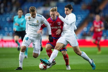 Los jugadores del Real Madrid Marcos Llorente y Jesús Vallejo intentan arrebatar el balón al centrocampista del Numancia, Daniel Nieto durante el partido.