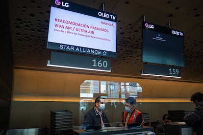 Trabajadores de Avianca atienden a los pasajeros varados por el cierre de Viva Air y Ultra Air, en el aeropuerto El Dorado en Bogotá