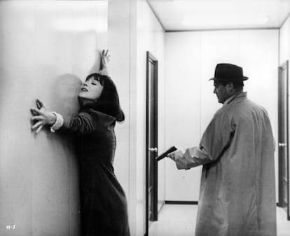 Eddie Constantine apunta con una pistola a Anna Karina en la película 'Alphaville' (1965) de Jean-Luc Godard.